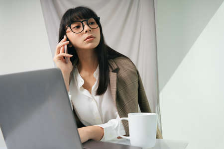 Business asian thai long dark hair woman wearing eyeglasses using laptop. Work from home concept.の写真素材
