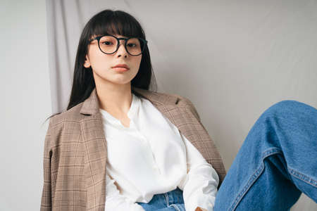 Beautiful asian thai long dark hair woman in white shirt wearing eyeglasses. Fashion portrait. Hipster.の写真素材
