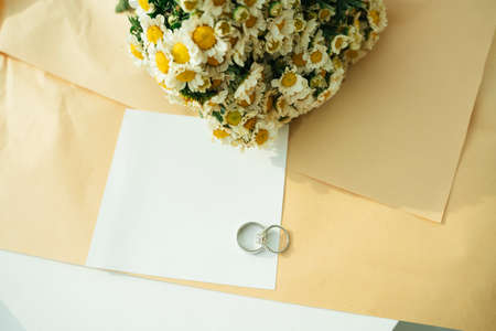 Wedding mock up paper with silver rings and paper and flower. Copy space.の写真素材