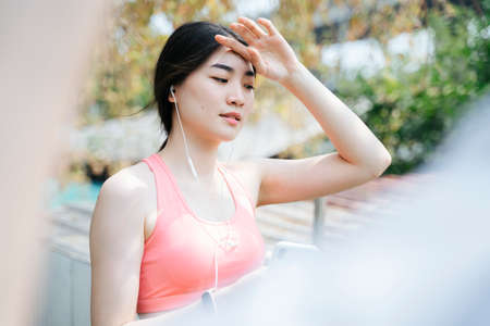 Long hair woman in old rose color sport bra say hi to her friend who run pass to her then wipe her...
