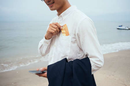 Cropped image of credit card is kept in the shirt pocket by the man.の写真素材