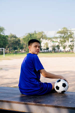 Portrait shot of a boy and his football on a stand looking at the camera.の写真素材