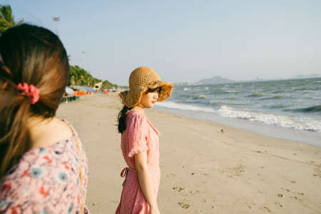 Lonely girl standing on the beach next to the sea.の写真素材