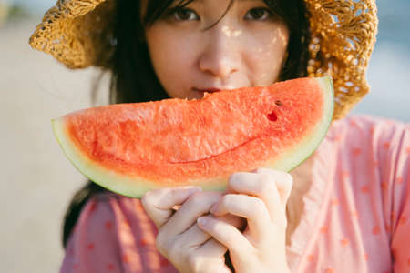 Cropped image of watermelon in cute girl's hands.