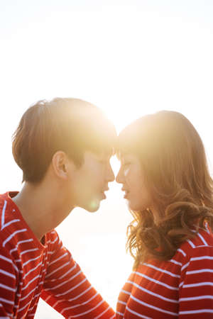 A guy's gonna kiss his girl in the evening with sunset, romantic scene in sunset.の写真素材