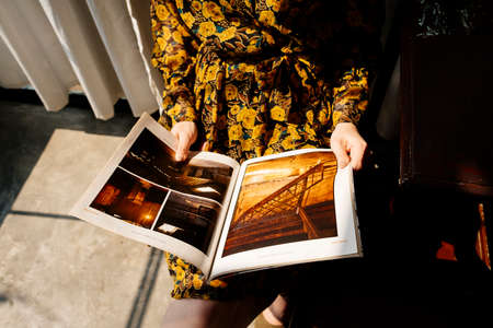 Cropped image of photobook in the girl's hands in sunlight.