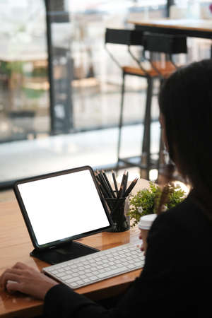 Closed up view with Blank tablet and Business women hold coffee cup in cafe.の写真素材