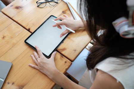 Top view with business women using tablet, blank screen of tablet computer on wooden table.の写真素材