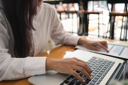Close up with business women working with her laptop and using data report for analysis, Business and finance concept.の写真素材