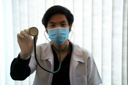 Closed up with a male physician wear mask and hold stethoscope, healthcare concept.