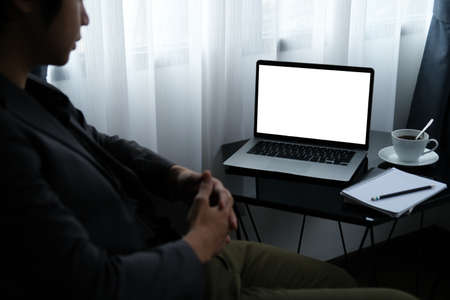 Closed up with businessman sitting and looking at empty display of laptop computer.の写真素材