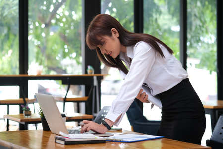 Side view with businesswoman working with laptop computer in standing positionの写真素材
