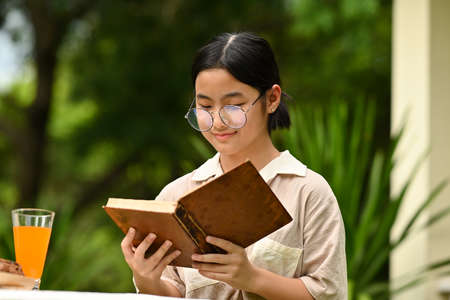 Portrait with Asian girl read a book in the garden.の写真素材