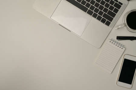Mock up with modern laptop computer, cup of coffee, mobile phone, writing note and pen on white background.の写真素材