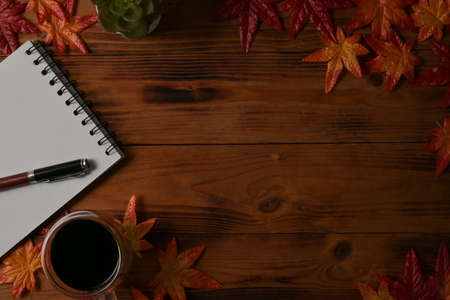 Mock up and top view with wooden desk, writing note, modern pen and americano coffee.の写真素材