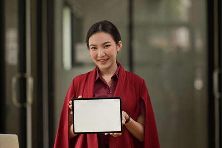 The woman who showing the empty screen of tablet.の写真素材