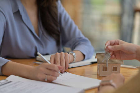 Portrait with Real estate agency signing a house purchase contract, model house.