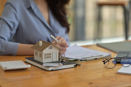 Portrait with Real estate agency signing a house purchase contract, model house.
