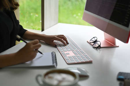 Closed up with women working on computer and sitting at the office desk.の写真素材