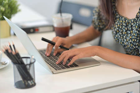 Closed up with woman hands typing on laptop keyboard, business and financial concept.の写真素材