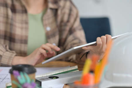 Cropped image of an architect woman using a digital tablet at the working table.の写真素材