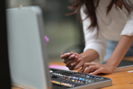 Cropped image of woman hands selecting a color from a crayon box on the wooden table.の写真素材