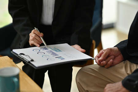 Cropped image of a young investment consultant using giving advice to elderly customers with a...