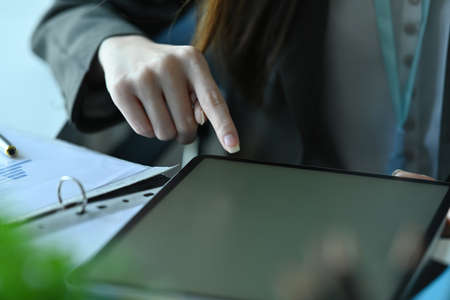 Cropped image of a female reception using a digital tablet at the modern reception counter.