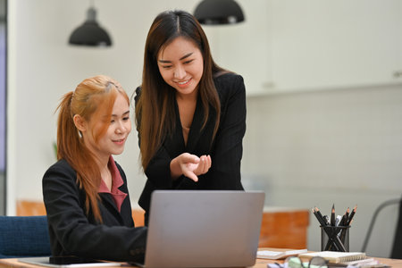 Two businesswomen sharing an idea, give an advice about the work.の写真素材