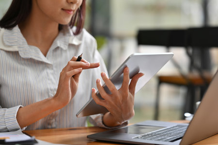 Close up or cropped image of Business and financial woman using tablet and laptop for working.の写真素材