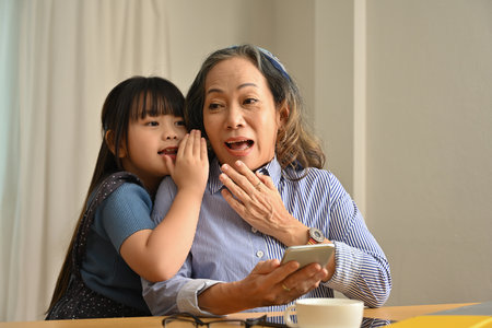 A little girl tell something surprising her granny, Excited granny, Special moment.