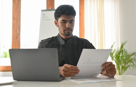 Administrator, businessman, Internal Revenue or financial inspector reading a report, calculating balance and Check the correctness of the document.の写真素材