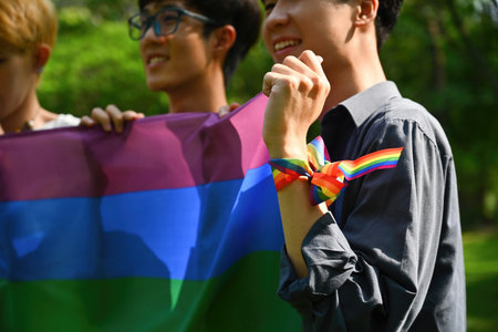Close up with LGBT parade by Young asian teenagers, Selective focus on hand with rainbow wristband...