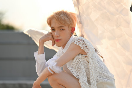 Portrait image of Attractive Young teenage boy with angel costume in sitting position.