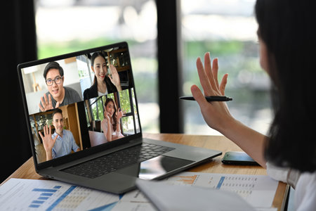 Online business meeting concept with greeting participants on laptop screen.