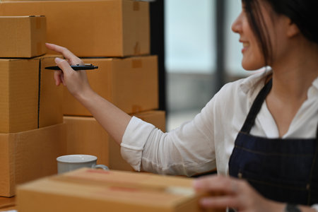 Cropped image of Asian woman entrepreneur, Small SME business owner counting parcel boxes and...