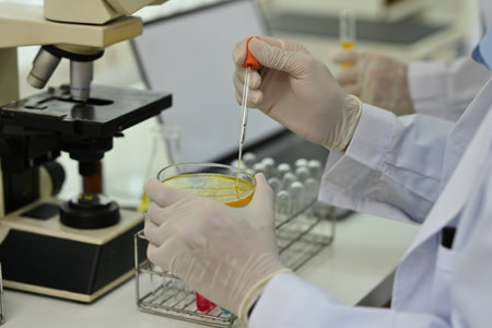 Close-up image of the researcher dropping the substance into the test dish..