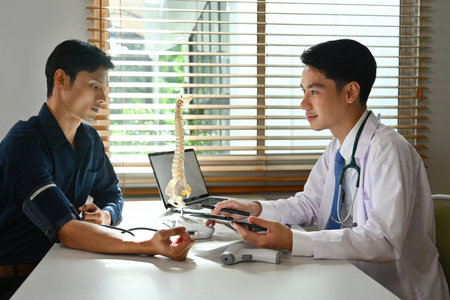 The doctor checking the blood pressure of a patient in the clinic.