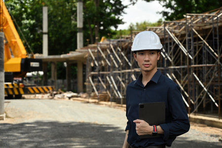Construction, an Asian Engineer man and digital tablet, inspection, manage work at job site.の写真素材