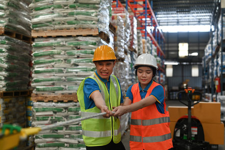 Group of industrial warehouse Asian workers doing tug of war as a teamwork concept.の写真素材
