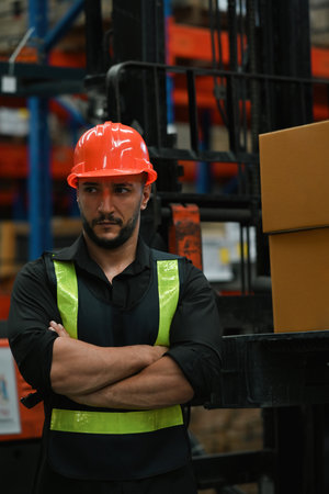 Vertical image of handsome Caucasian worker portrait with forklift.の写真素材