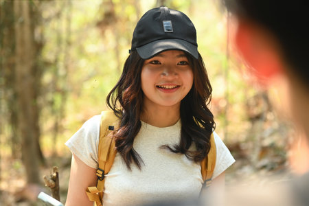 Close-up with teenage girl with a backpack looking to her friend, Trekking on summer vacations.の写真素材