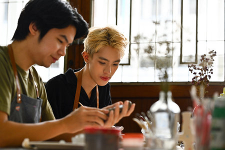 Art workshop with Two friends enjoy learning to make a DIY handcraft ceramic, Art and craft concepts.の写真素材