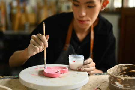 Selective focus of hand painting a clay piece during art class It showcases the dedication and skills of young LGBT students.の写真素材