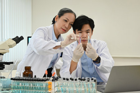 Two professional Asian scientists focus on chemistry test tubes Observation in the laboratory.の写真素材