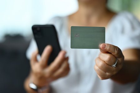 Close-up old woman showing a credit or debit card, internet payments, online shopping, and online banking services.の写真素材