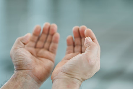 Close-up of a Muslim man praying with hands up in the air in the mosque, Religion praying concept.の写真素材