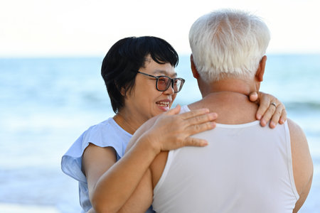 Happy and Romantic Senior Couple hugging together on the beach with the seascape as the background.の写真素材