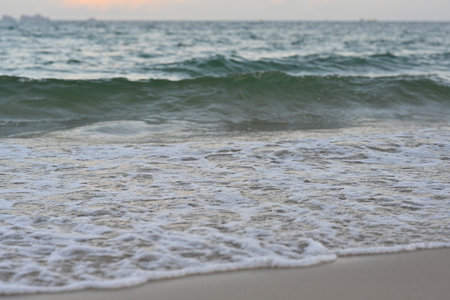 Soft foam wave of the sea on the sandy beach.