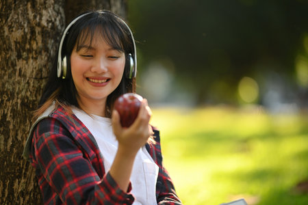 Portrait of a Happy Teenage student girl looking at while wearing headphones, Outdoor.